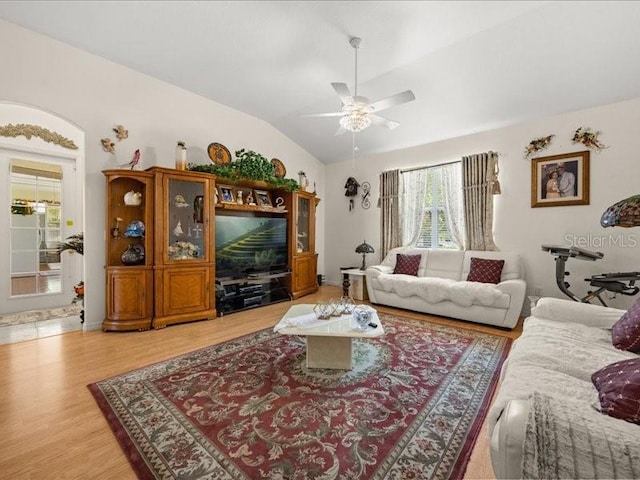 living room featuring a ceiling fan, light wood finished floors, and lofted ceiling