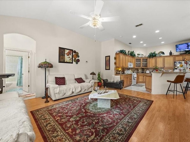 living area featuring light wood-style flooring, a ceiling fan, recessed lighting, and vaulted ceiling