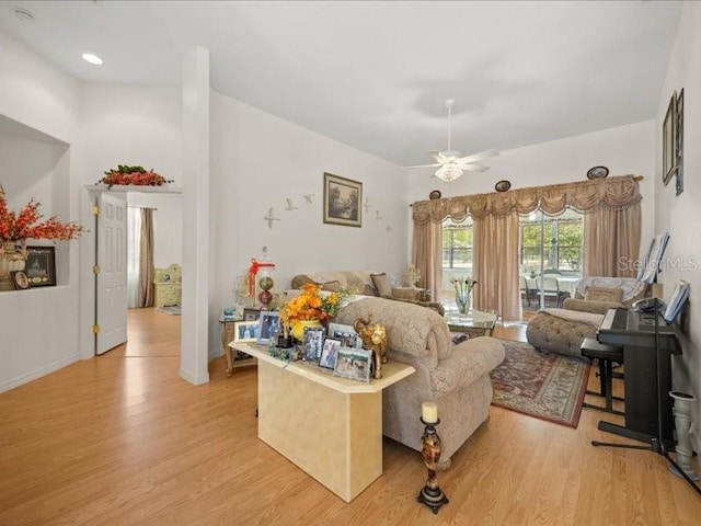 living area featuring light wood-type flooring and a ceiling fan