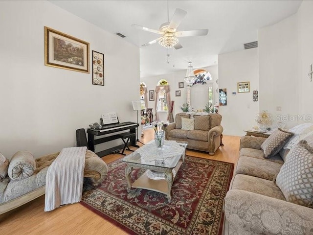 living area with wood finished floors, ceiling fan, and vaulted ceiling