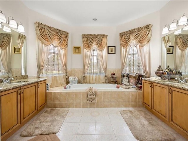 bathroom featuring a garden tub, tile patterned flooring, and two vanities