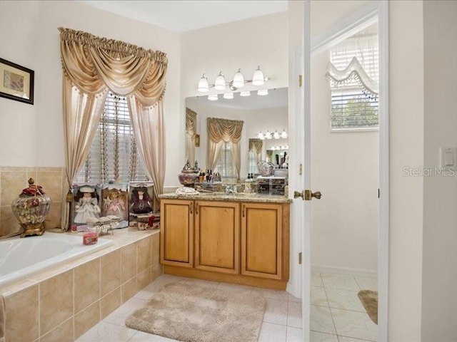 bathroom with tile patterned floors, plenty of natural light, vanity, and a garden tub