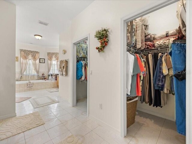 hall with baseboards and tile patterned floors
