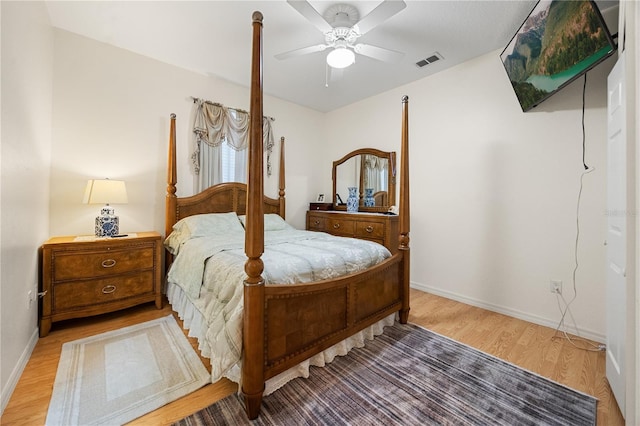 bedroom with light wood finished floors, baseboards, and a ceiling fan
