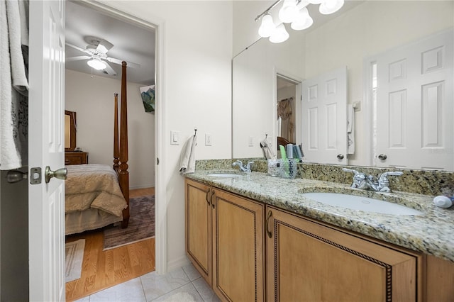 full bathroom with ceiling fan, ensuite bathroom, double vanity, tile patterned floors, and baseboards
