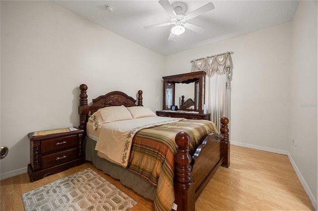 bedroom featuring baseboards, light wood-type flooring, and a ceiling fan