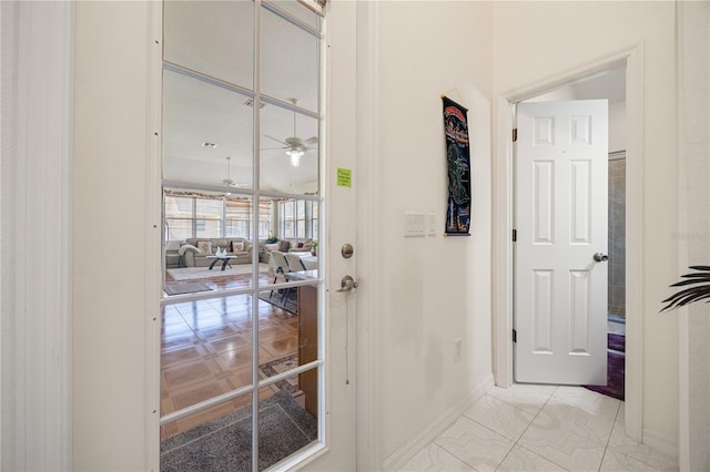 corridor featuring baseboards and light tile patterned flooring