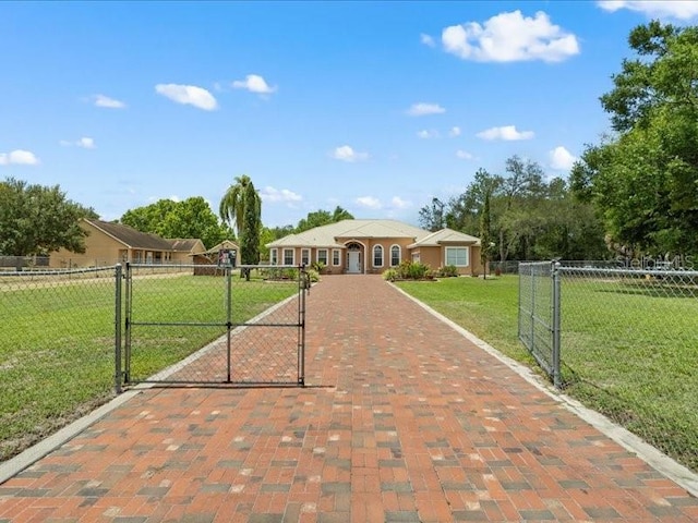 ranch-style house featuring decorative driveway and a gate