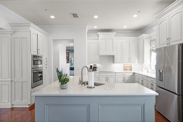 kitchen featuring stainless steel appliances, a sink, dark wood-type flooring, light countertops, and white cabinetry