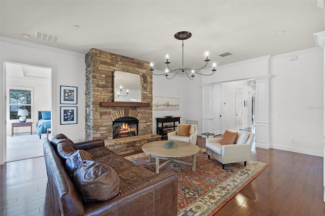 living room featuring dark wood-style floors, ornamental molding, a fireplace, a chandelier, and baseboards