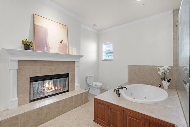 bathroom with ornamental molding, a tile fireplace, a jetted tub, toilet, and tile patterned floors