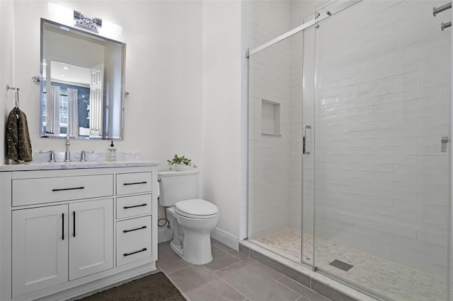 full bathroom featuring toilet, a stall shower, and vanity