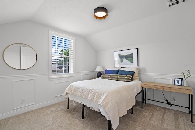 bedroom with lofted ceiling, carpet floors, and a wainscoted wall