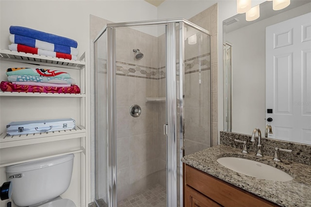 bathroom with a shower stall, vanity, and toilet