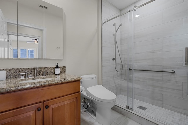 bathroom featuring toilet, a shower stall, vanity, ceiling fan, and tile patterned flooring
