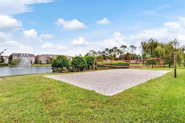 view of property's community featuring a water view, volleyball court, and a lawn
