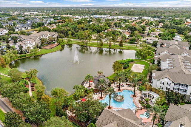 aerial perspective of suburban area featuring a nearby body of water and a pool
