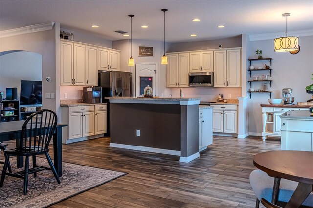 459 Millwood Pl, Winter Garden, FL 34787 - kitchen featuring ornamental molding, visible vents, stainless steel microwave, arched walkways, and an island with sink