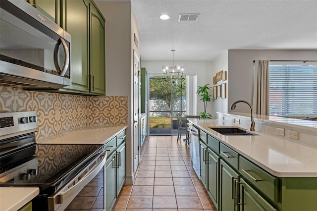 570 Cascading Creek Ln, Winter Garden, FL 34787 - kitchen with green cabinetry, stainless steel appliances, a sink, a chandelier, and a textured ceiling