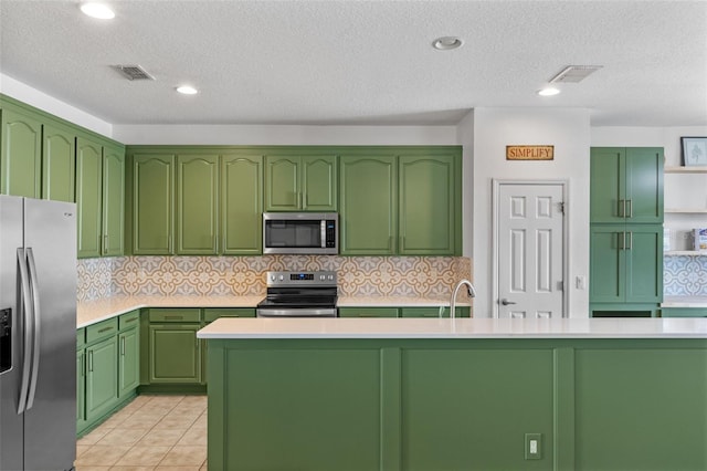 570 Cascading Creek Ln, Winter Garden, FL 34787 - kitchen with stainless steel appliances, light countertops, decorative backsplash, a textured ceiling, and a center island with sink