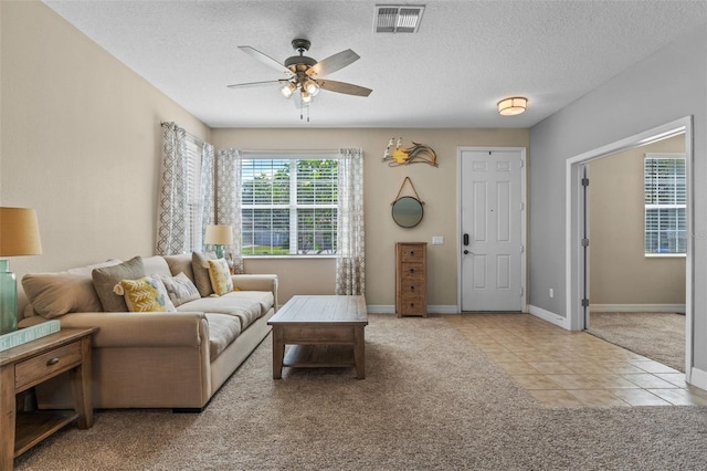 570 Cascading Creek Ln, Winter Garden, FL 34787 - carpeted living room with a ceiling fan, tile patterned flooring, baseboards, and a textured ceiling