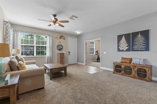 570 Cascading Creek Ln, Winter Garden, FL 34787 - carpeted living room featuring ceiling fan, a textured ceiling, baseboards, and tile patterned flooring