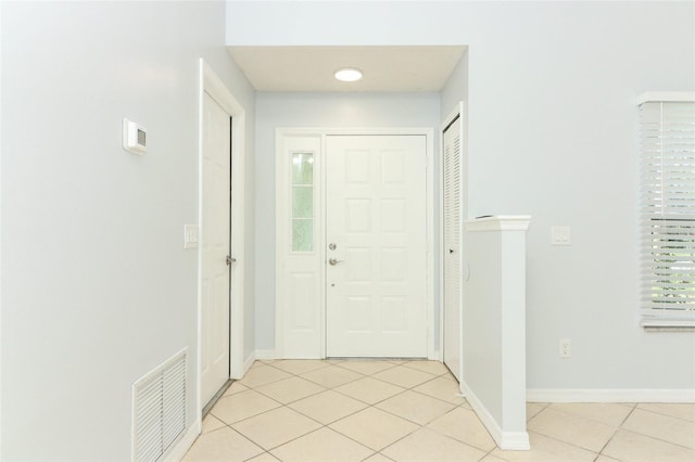 entryway featuring light tile patterned flooring, baseboards, and plenty of natural light