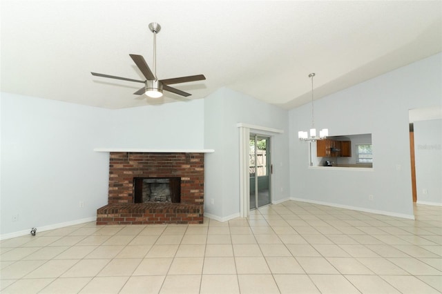 unfurnished living room featuring vaulted ceiling, a chandelier, ceiling fan, a brick fireplace, and baseboards