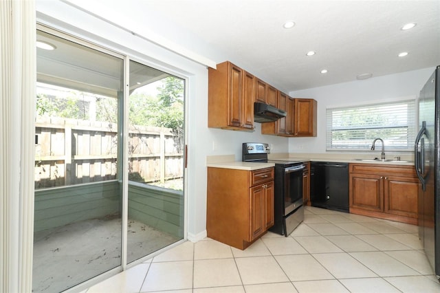 kitchen with black appliances, under cabinet range hood, a sink, brown cabinetry, and recessed lighting