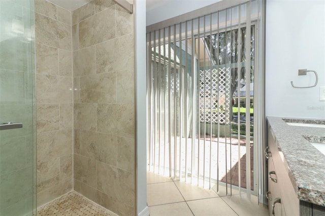full bathroom with a stall shower, vanity, and tile patterned floors