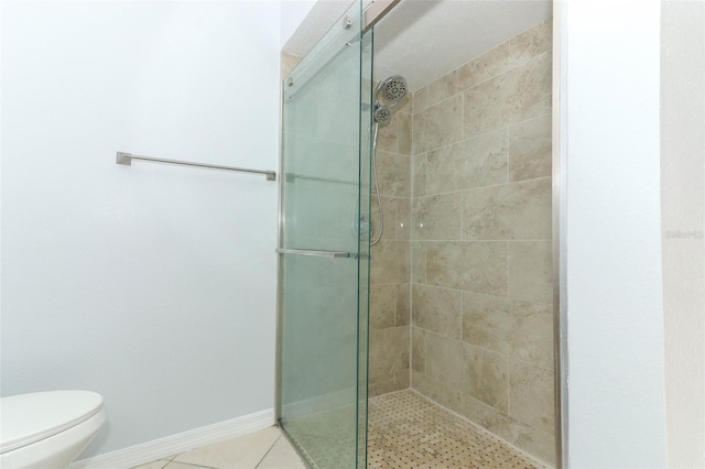 bathroom featuring a shower stall, toilet, and tile patterned flooring