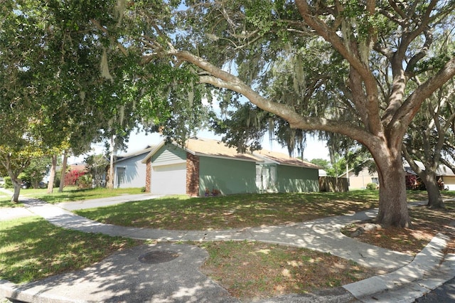 view of front of property featuring a front lawn, brick siding, and a garage