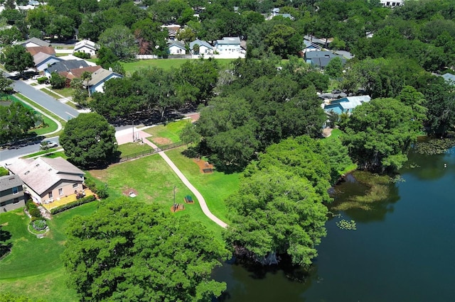 aerial overview of property's location featuring a large body of water, nearby suburban area, and a tree filled landscape