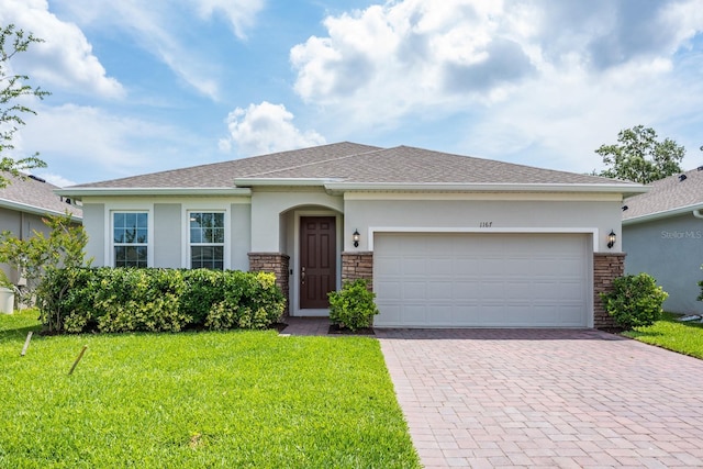 view of front of property featuring stucco siding, decorative driveway, a front yard, and a garage