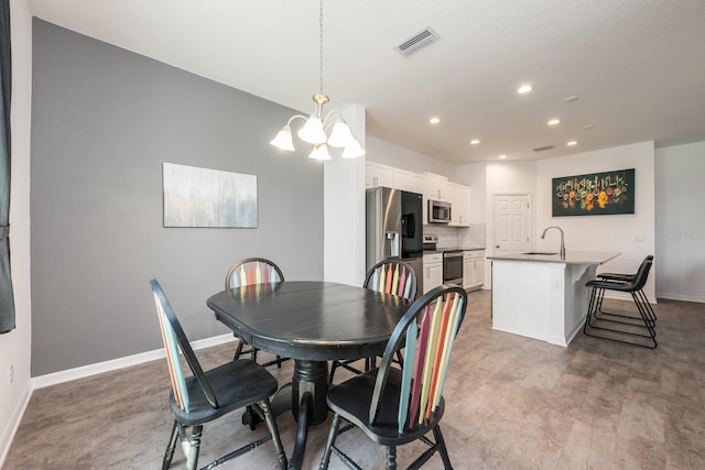 dining room featuring a chandelier, recessed lighting, and baseboards