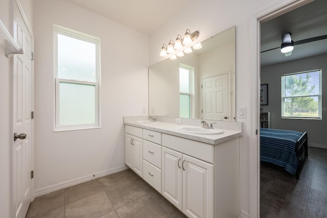 full bath with baseboards, connected bathroom, and double vanity