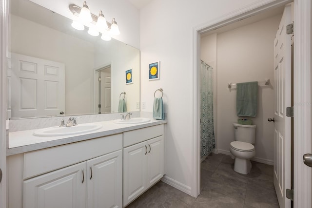 bathroom featuring double vanity, toilet, tile patterned flooring, and baseboards