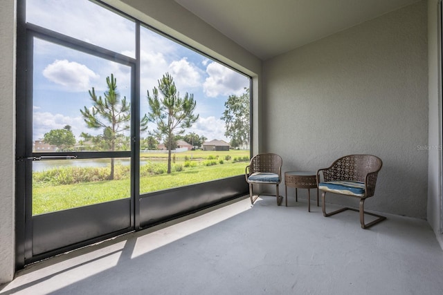 sunroom featuring a water view