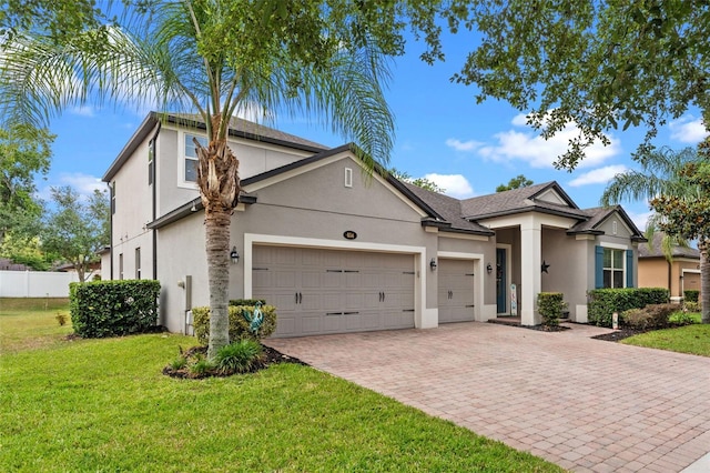 traditional-style house featuring decorative driveway, a garage, and stucco siding