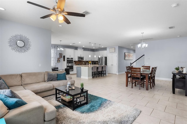 living room with a chandelier, recessed lighting, ceiling fan, light tile patterned floors, and baseboards