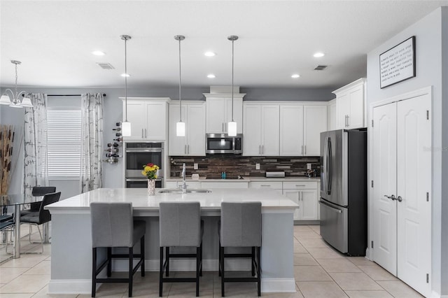 kitchen with stainless steel appliances, a sink, light tile patterned floors, backsplash, and recessed lighting