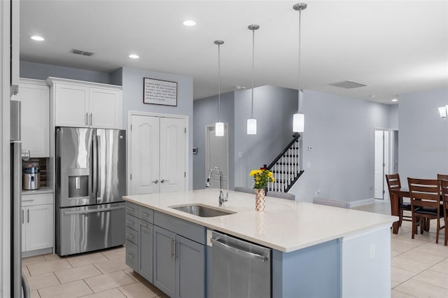 kitchen featuring appliances with stainless steel finishes, a sink, light tile patterned floors, white cabinetry, and recessed lighting