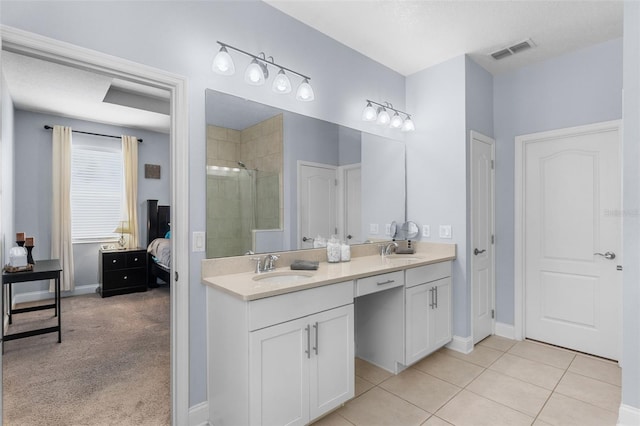 full bathroom featuring a stall shower, double vanity, baseboards, tile patterned floors, and connected bathroom