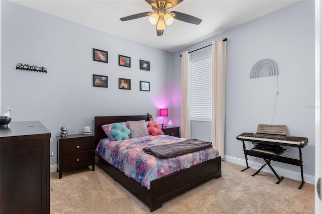 bedroom featuring light colored carpet, baseboards, and a ceiling fan