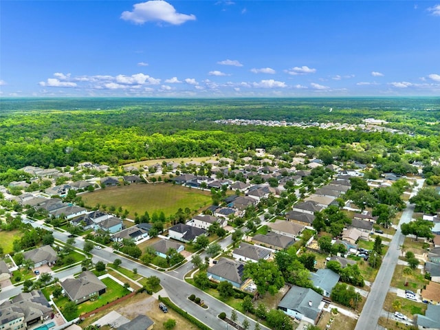 aerial view of property's location with a forest and nearby suburban area