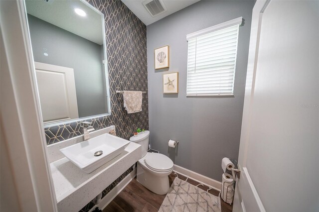 1631 Pontiff Pl, Davenport, FL 33896 - bathroom featuring a sink, toilet, wallpapered walls, wood finished floors, and baseboards