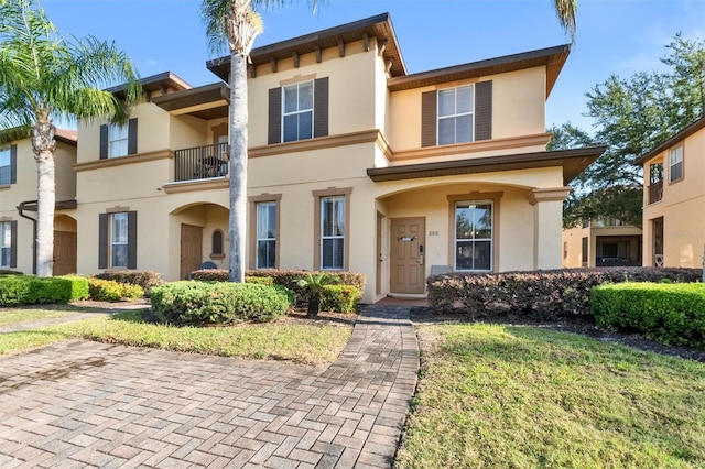 view of front of home featuring stucco siding and a front yard