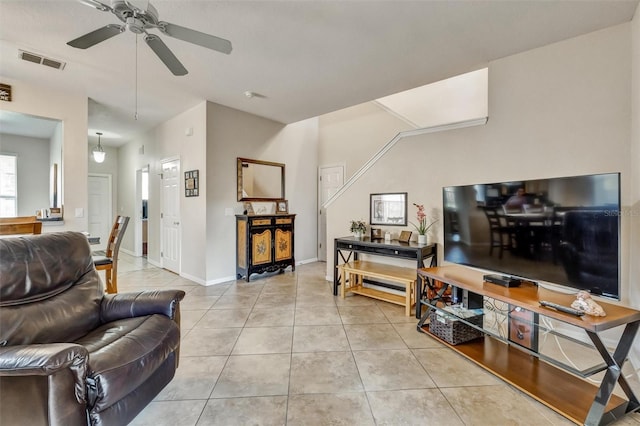 living room with light tile patterned floors, baseboards, visible vents, and a ceiling fan