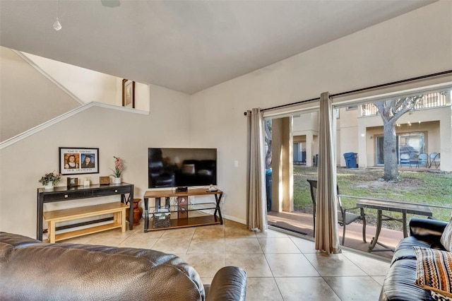living room featuring tile patterned floors, baseboards, and lofted ceiling