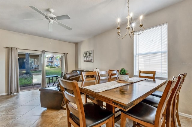 dining space featuring baseboards, light tile patterned flooring, and ceiling fan with notable chandelier